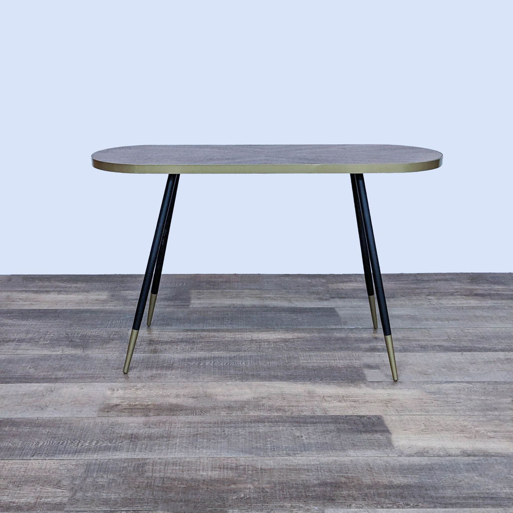 Baxton Studio side table with black and gold splayed legs and metal top banding.
