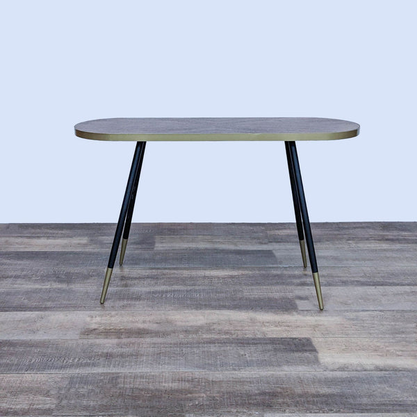 Baxton Studio side table with black and gold splayed legs and metal top banding.