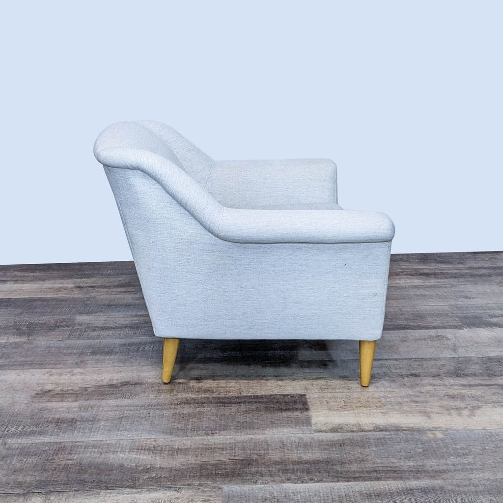 Side view of a West Elm lounge chair showcasing its angled backrest and sturdy design.