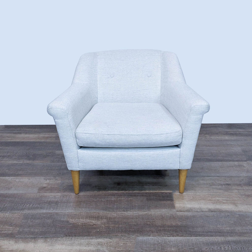 Front view of a cozy West Elm lounge chair with soft fabric and wooden legs.