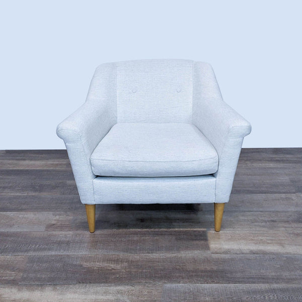 Front view of a cozy West Elm lounge chair with soft fabric and wooden legs.
