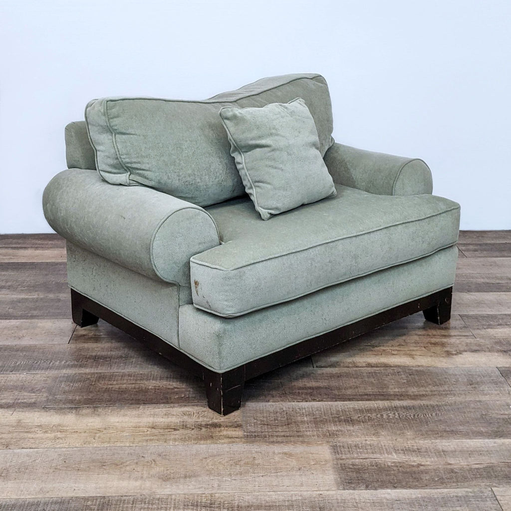 Classic lounge chair with rounded arms and dark wood frame.