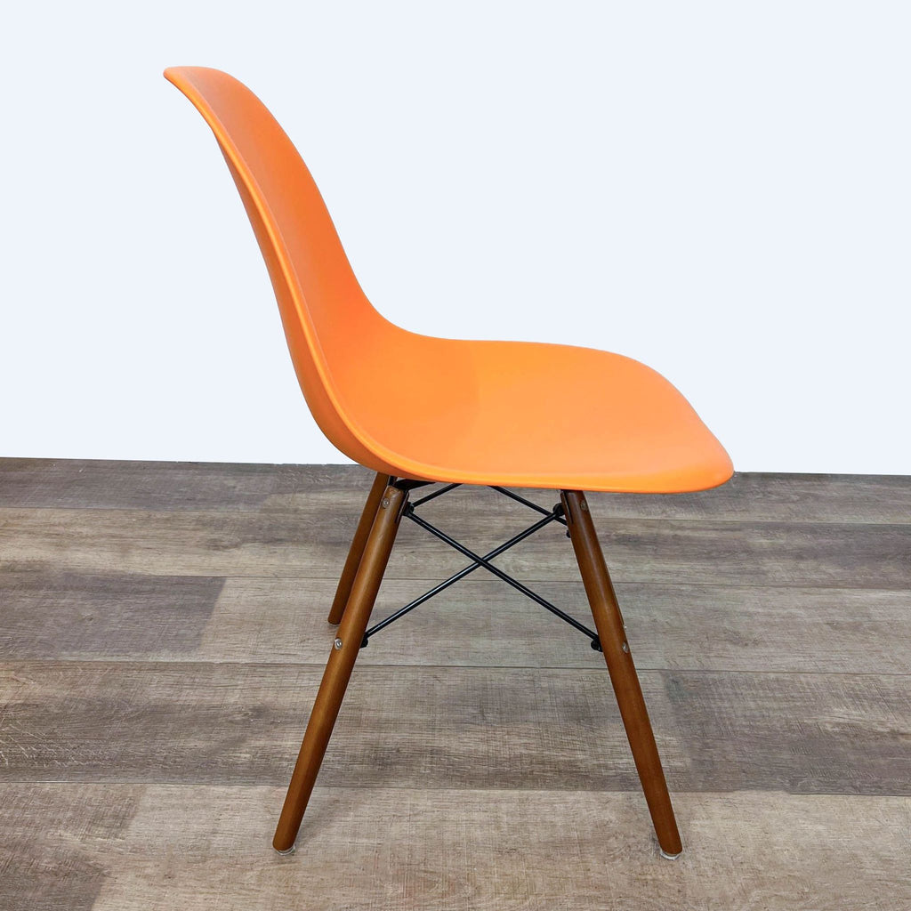 Side view of orange Reperch dining chair on wooden floor.