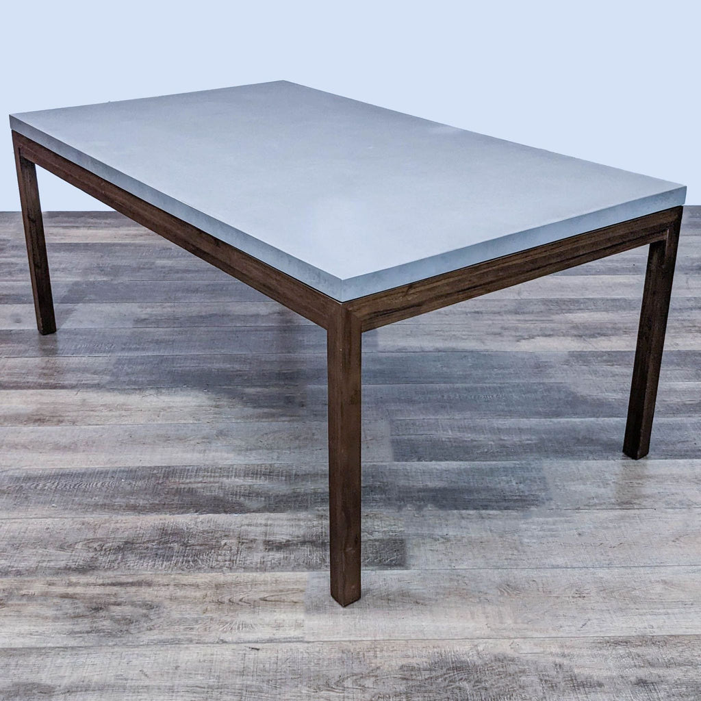 Walnut stained base dining table with concrete top in Parsons style by Reperch.