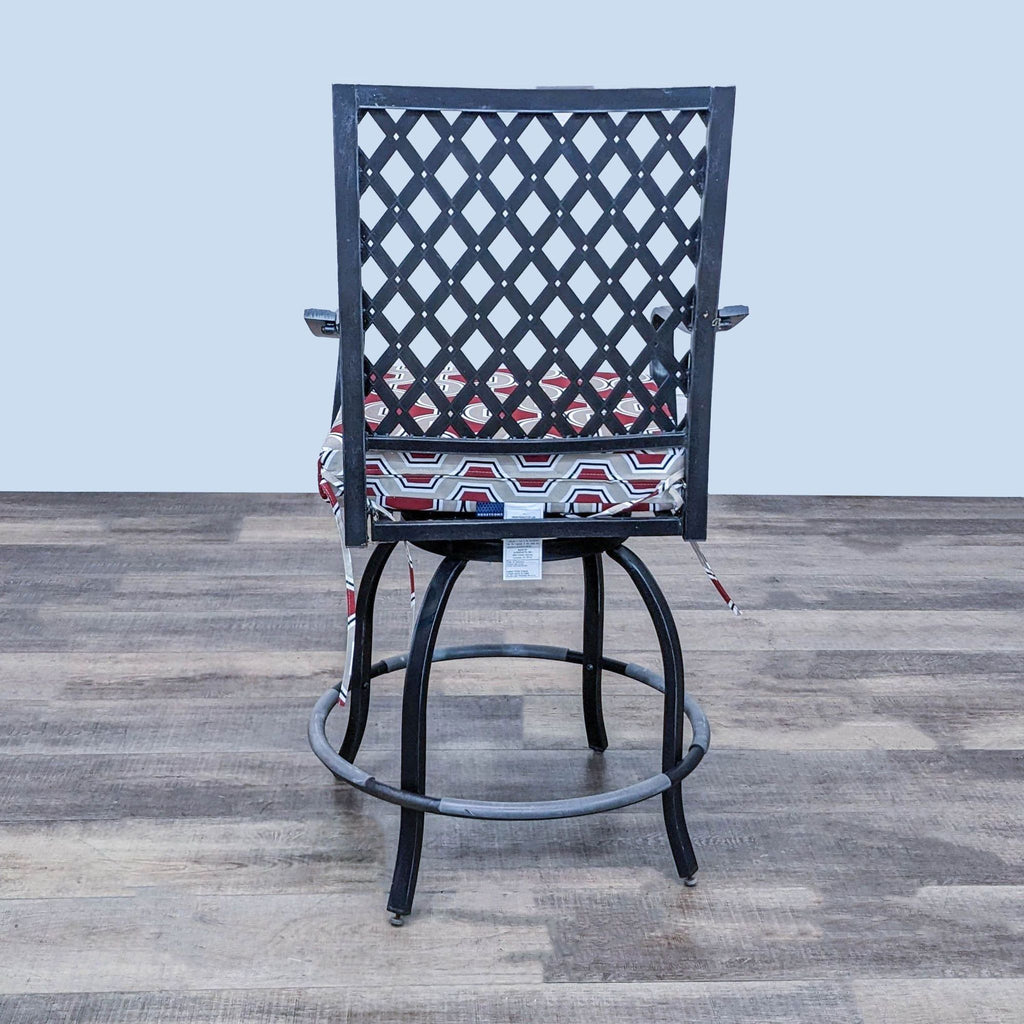 Back view of swivel chair with metal lattice design and cushion.