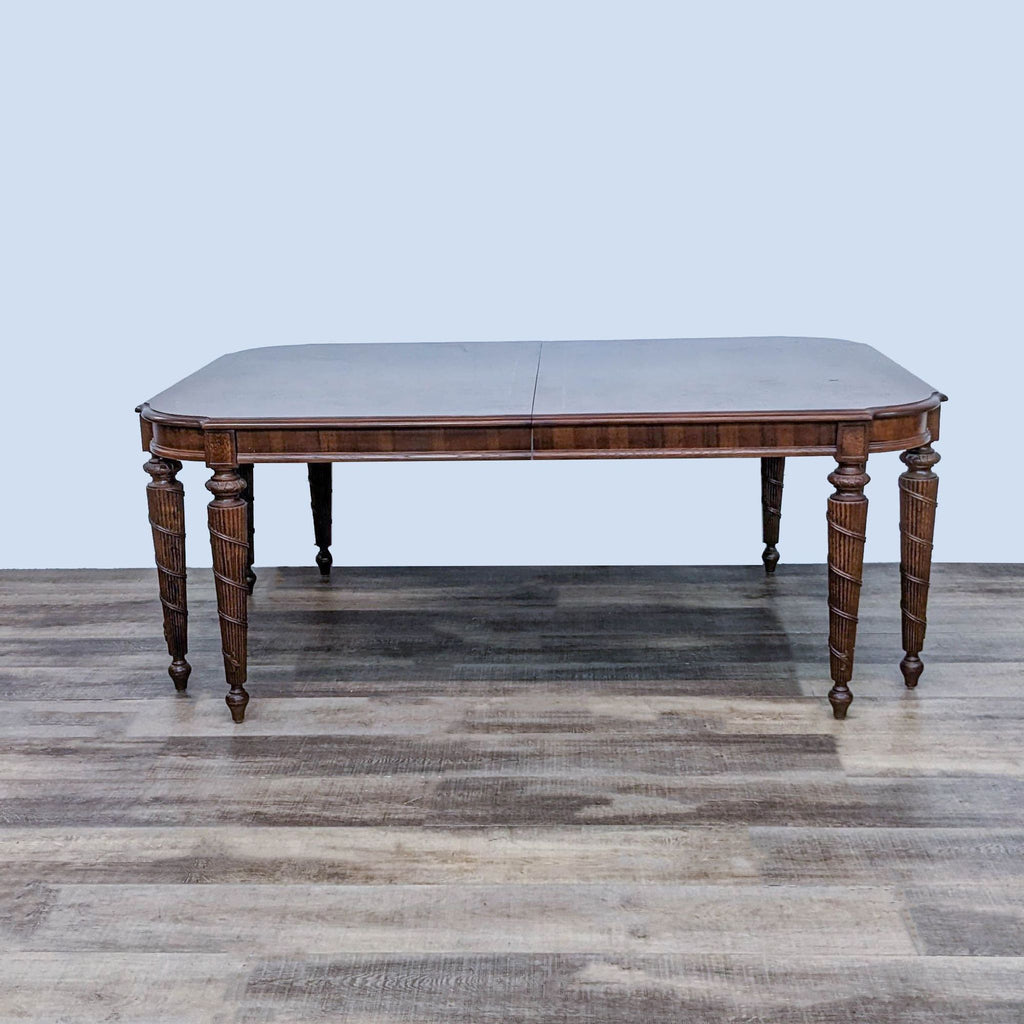 Elegant Lane wooden extendable dining table with carved detailing on legs, shown without chairs to highlight design and functionality.