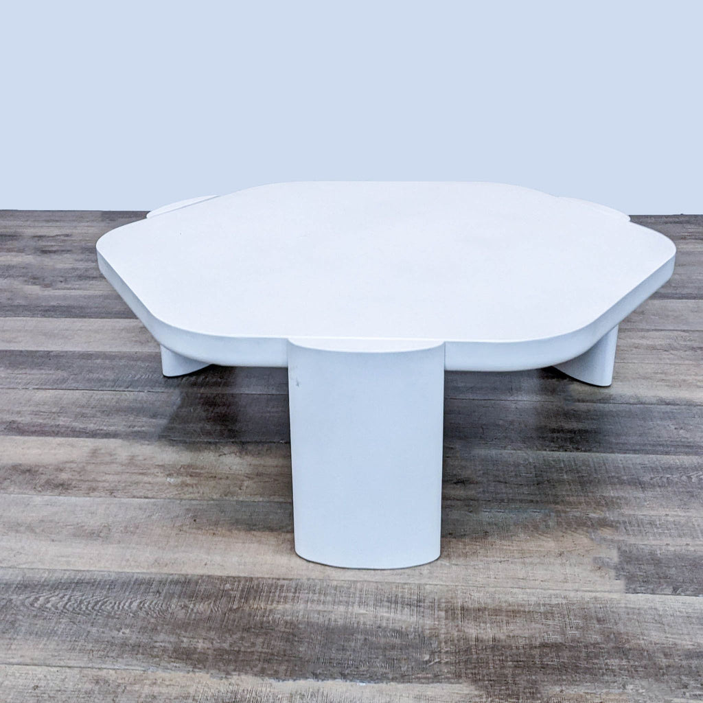 Contemporary Pro-Living Asia coffee table in white, featuring a unique base, set on a textured wood floor.