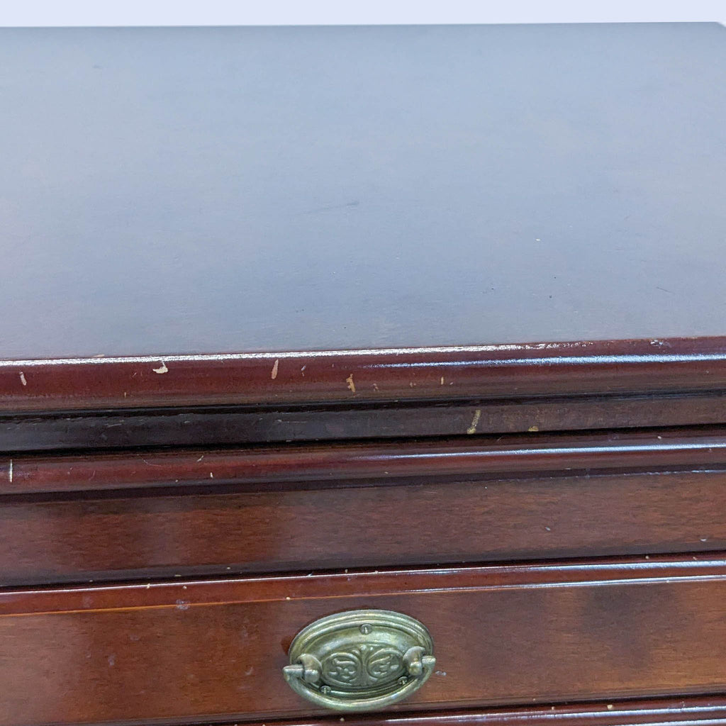 Close-up of armoire's top detail and drawer handle.