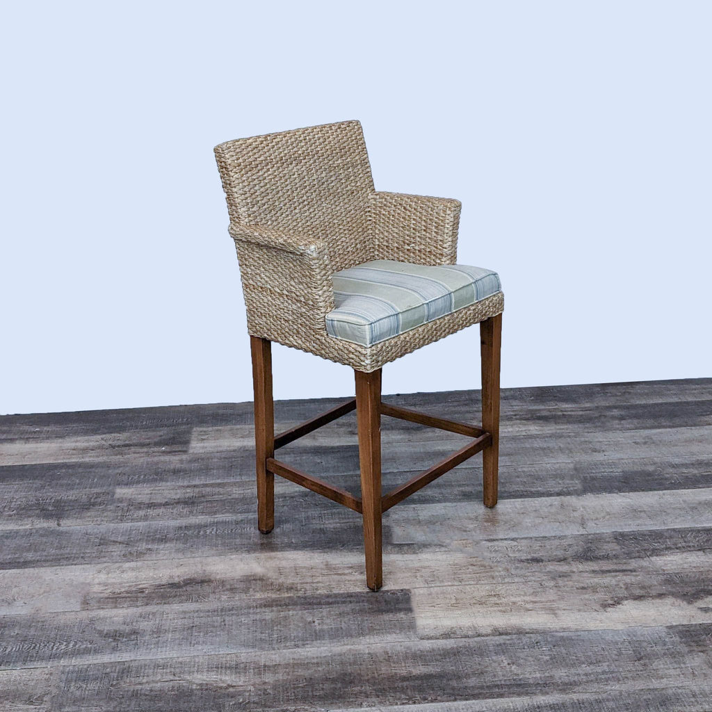 Reperch seagrass stool featuring plaid cushion, wooden frame, angled side view.