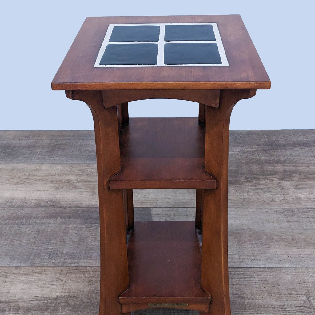 Square wooden console table with a tiled top, featuring open slatted sides and lower shelves.