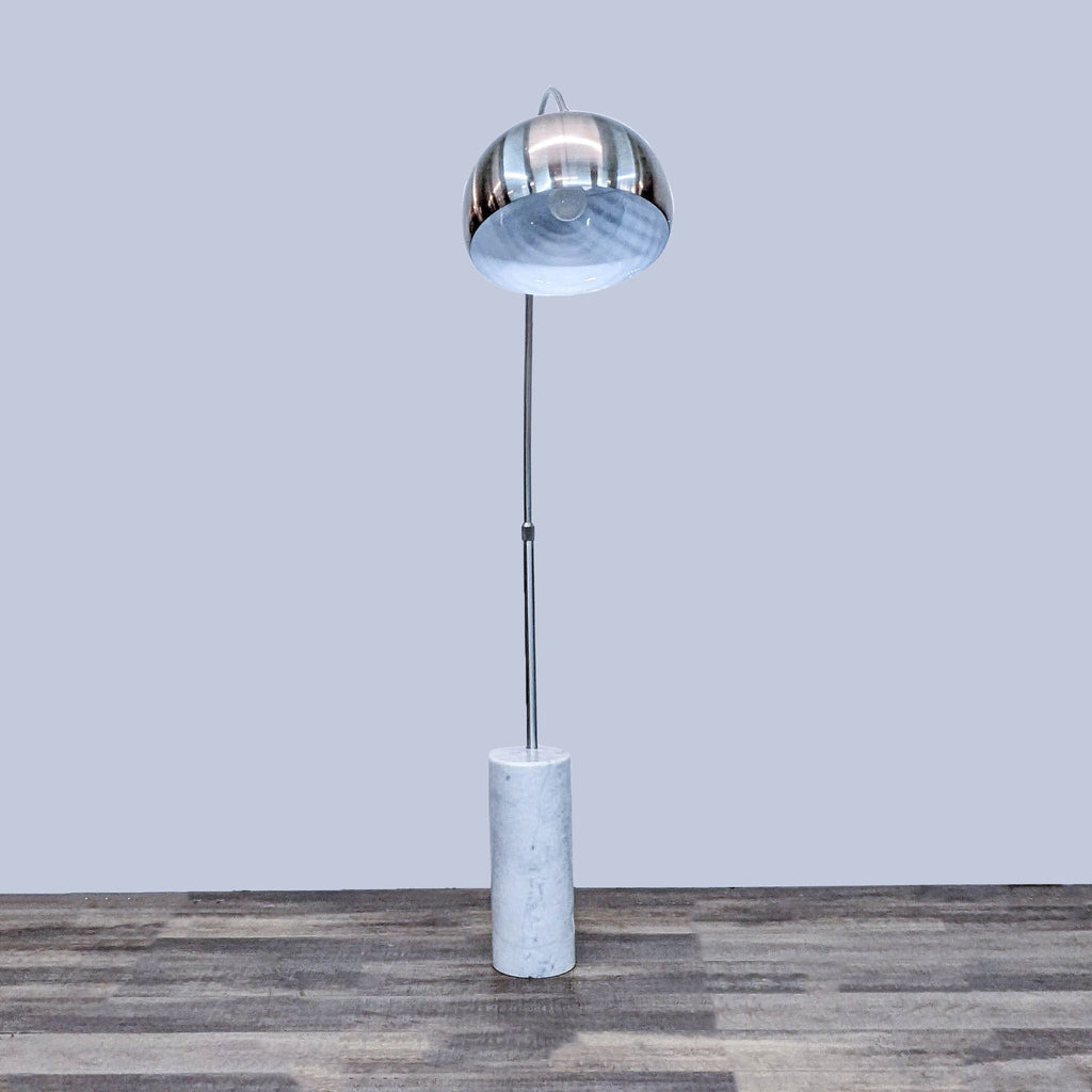Modern Reperch arc floor lamp with sturdy cylindrical stone base and metallic shade, designed for stability.