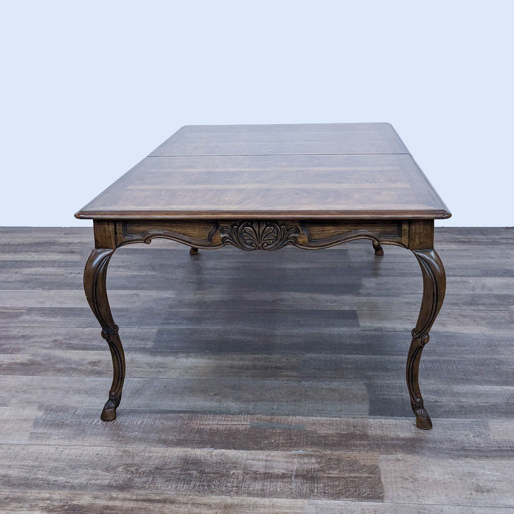 Elegant Drexel Heritage wooden dining table with carved trim and cabriole legs.
