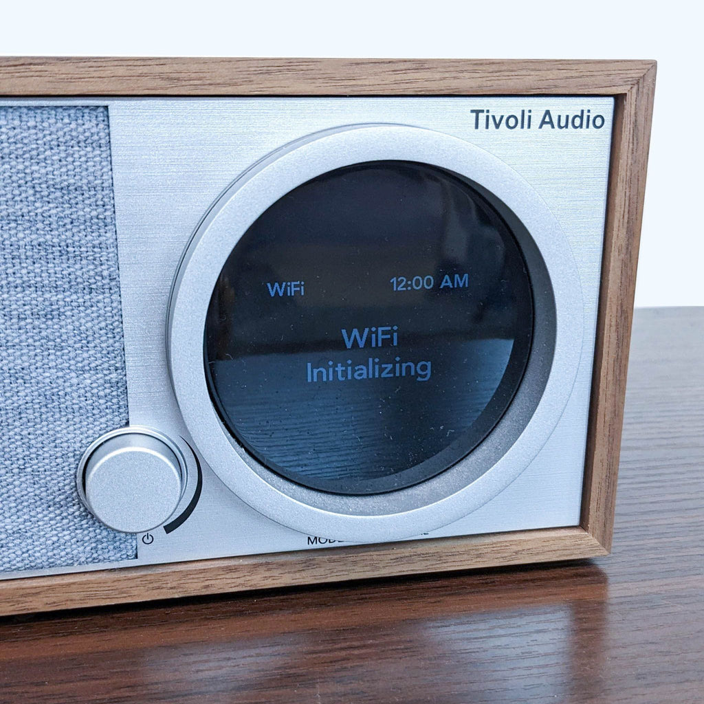 Close-up of Tivoli Audio display and dial, set in a sleek walnut and fabric design, Wi-Fi initializing.