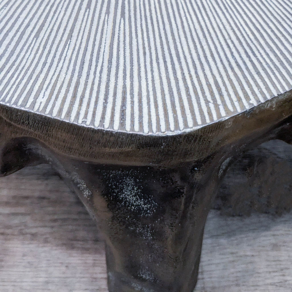 Close-up of lily pad-shaped table's detailed, textured surface with brass patina finish.