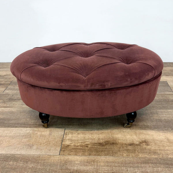 Round velvet ottoman with tufted top and wooden feet on casters, from World Market.
