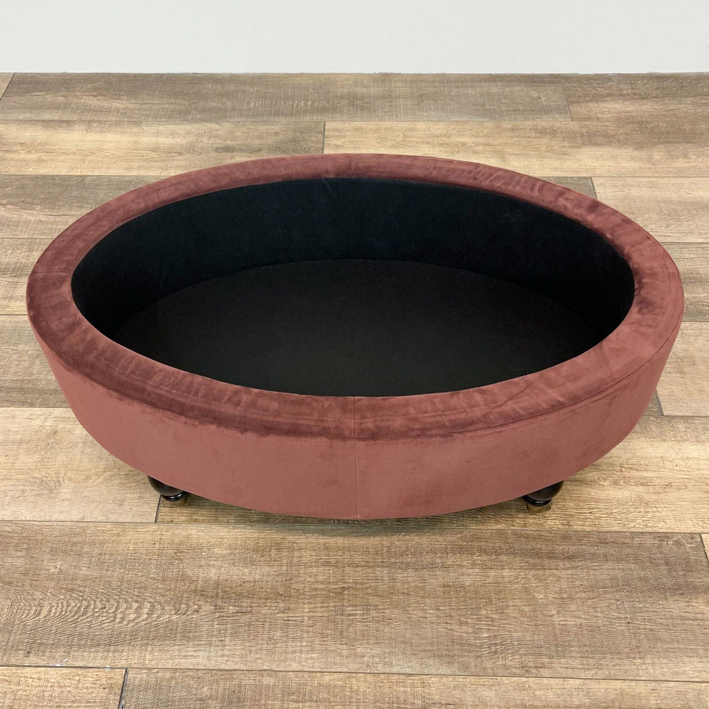 Open top view of an oval velvet storage ottoman, showcasing interior space.