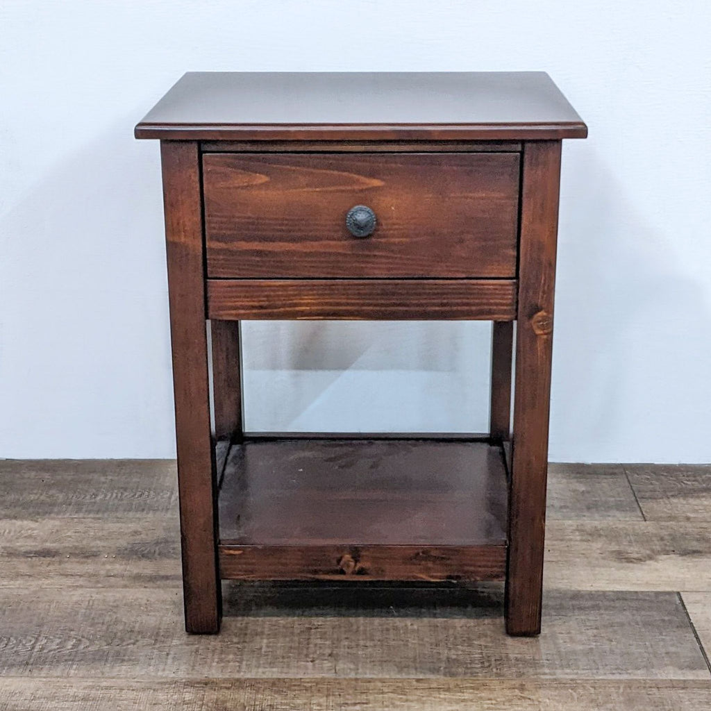 Dark wooden end table with a single drawer and shelf by Pottery Barn Kids.