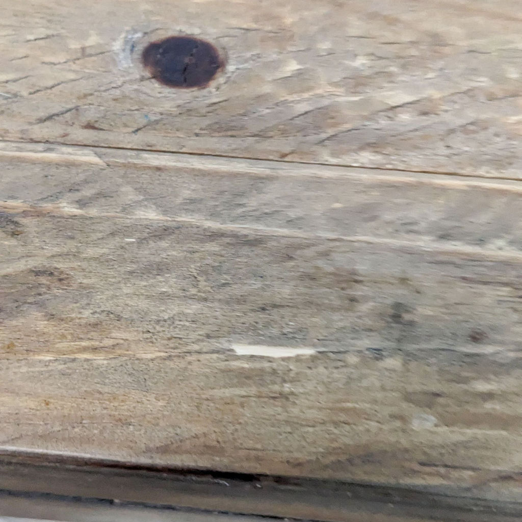Detailed view of wooden table surface, highlighting texture and imperfections.