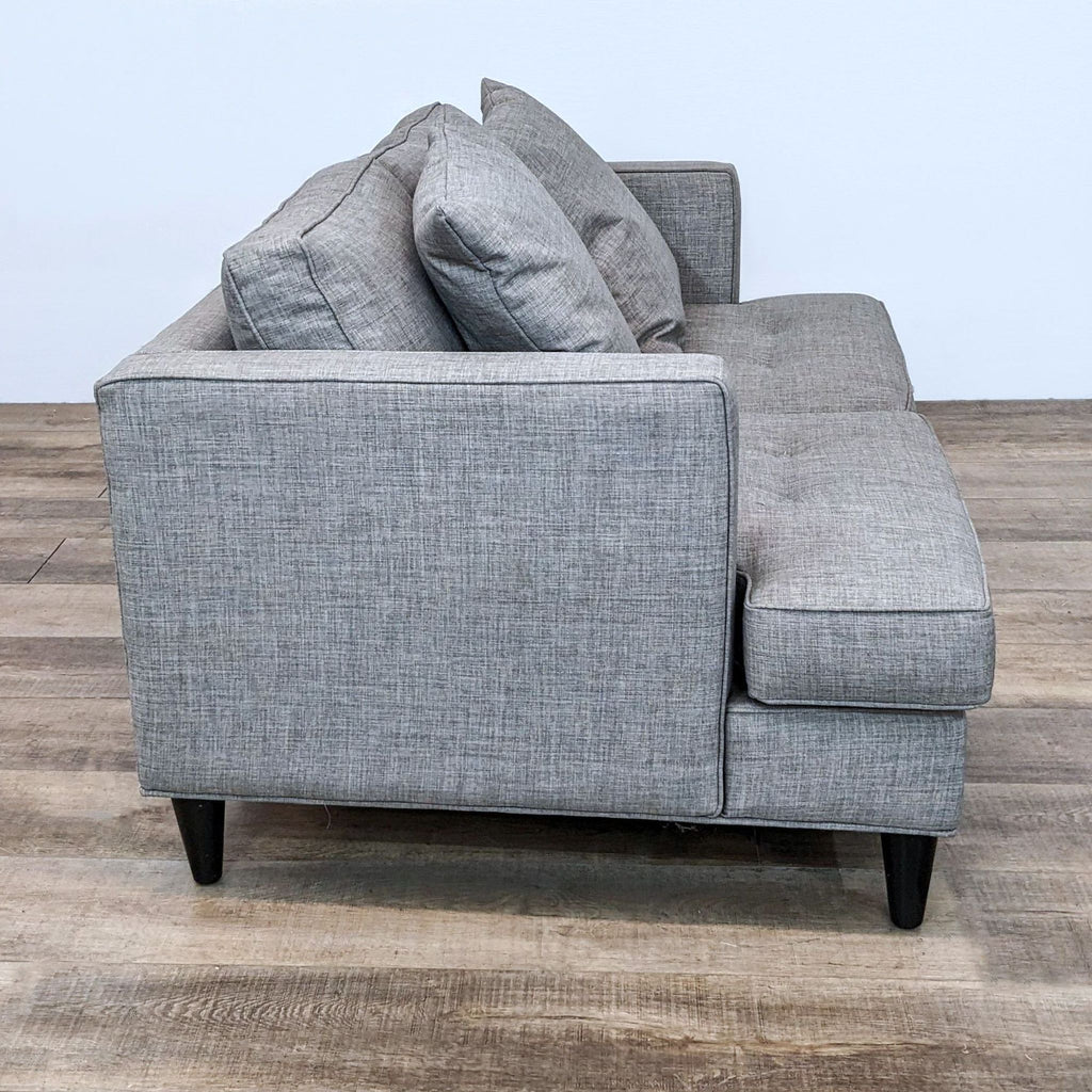 Tufted loveseat with two cushions and sleek design.