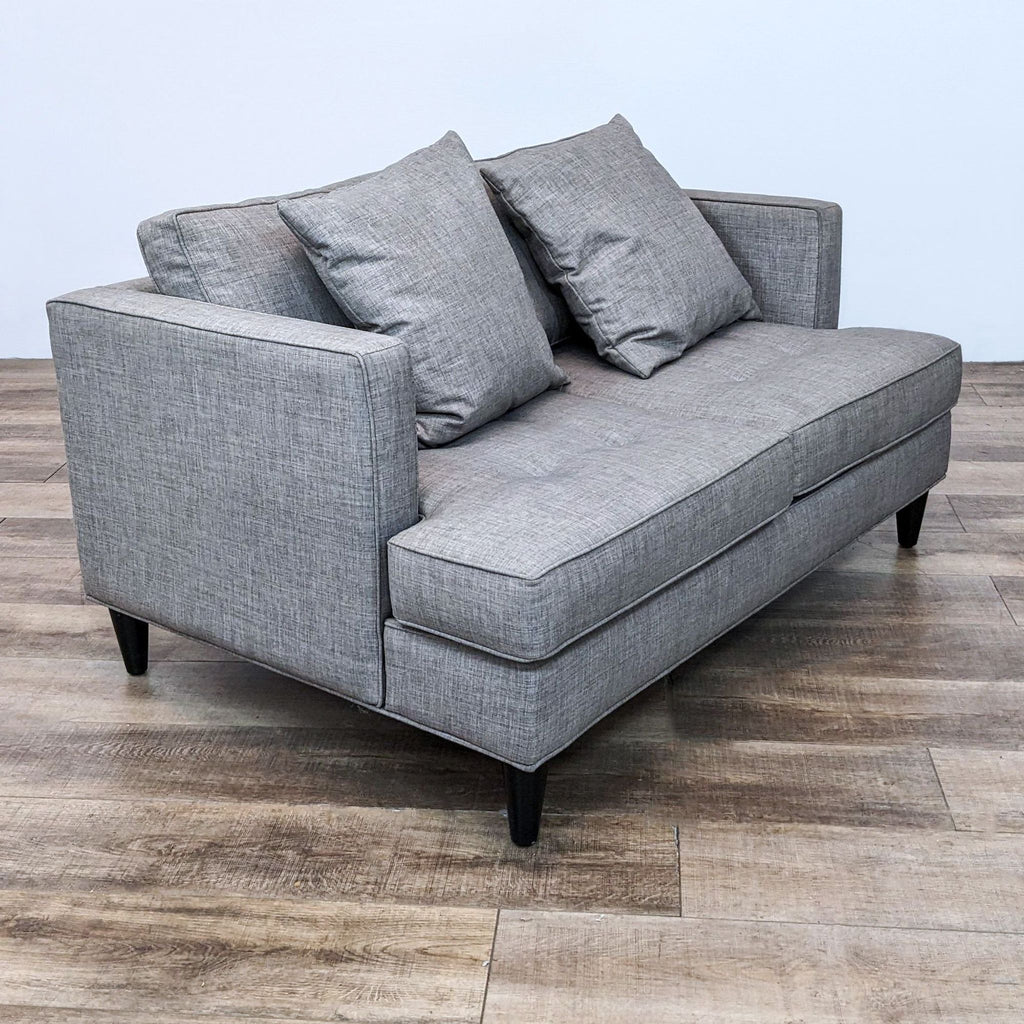 Reperch gray loveseat on dark wood finish feet, side view.