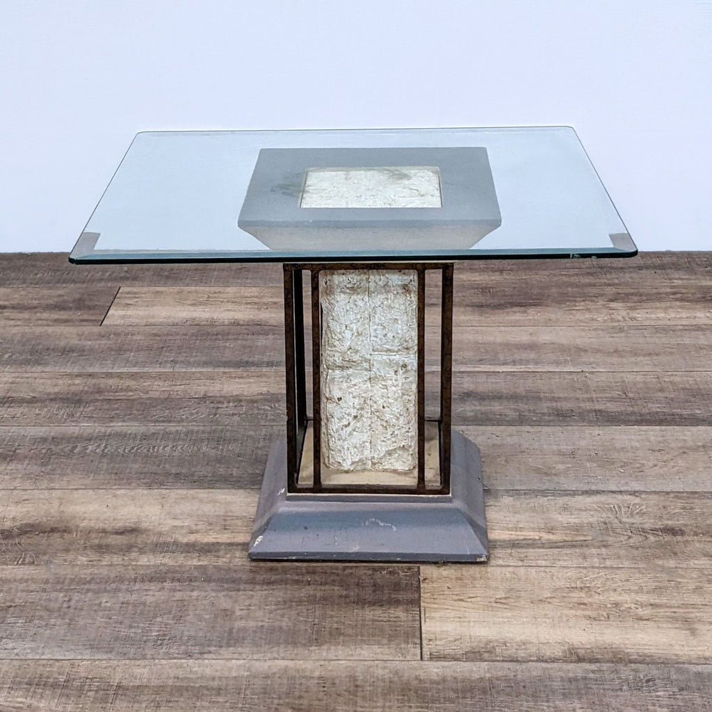 Modern Reperch end table featuring a clear glass top with a unique metal and plaster base on a wooden surface.