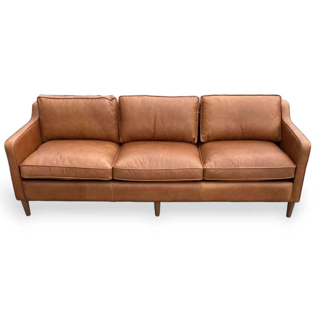 Modern brown leather sofa with narrow arms and wooden legs.