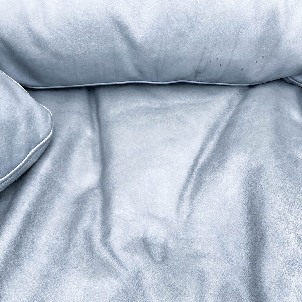 3. Close-up texture of a gray leather sectional with visible wrinkles and a soft surface, by Restoration Hardware.