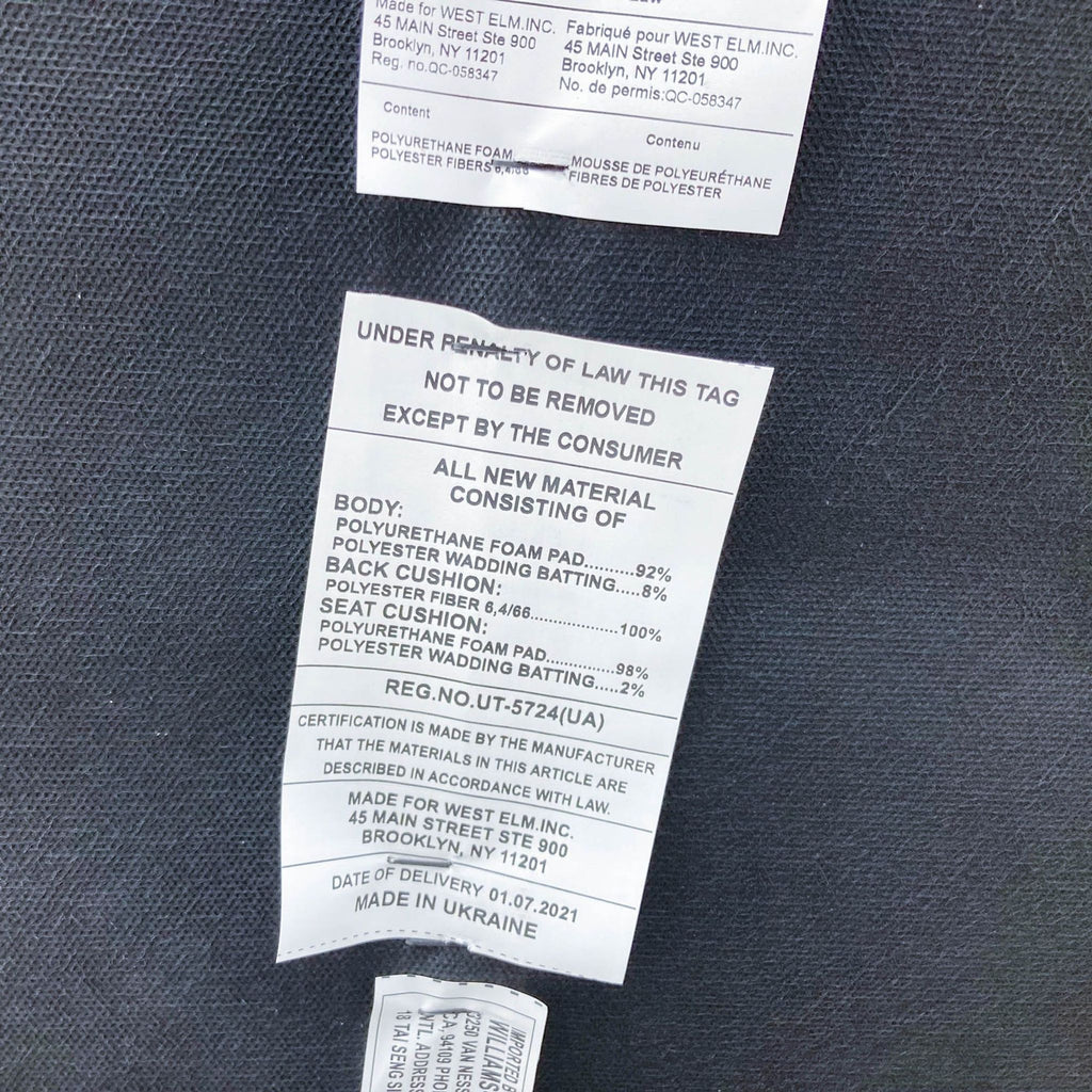 2. Close-up of tags on a West Elm sofa detailing material composition and manufacturing information.