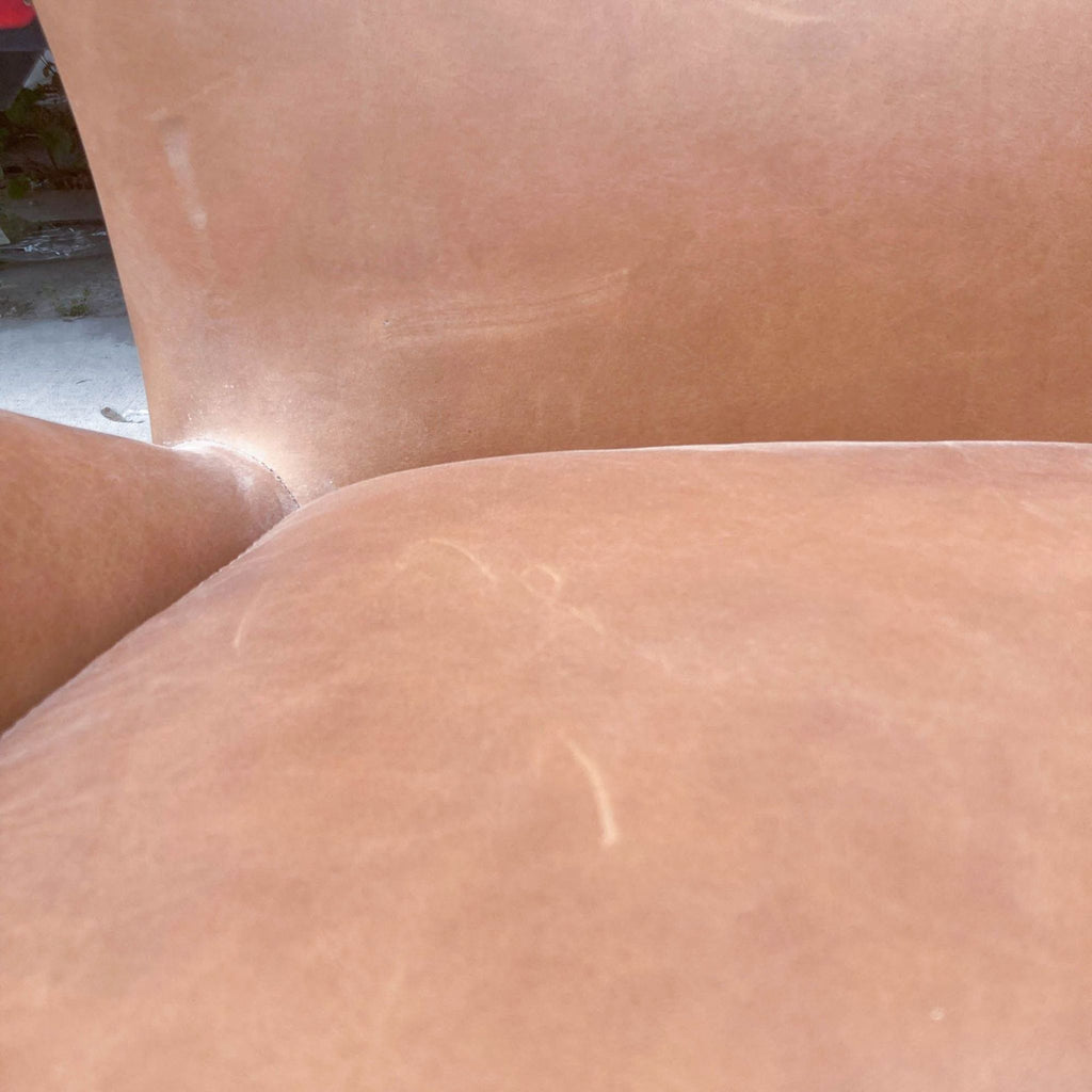 2. Close-up of the leather upholstery on the West Elm Hemming Swivel Armchair, showcasing its texture and patina.