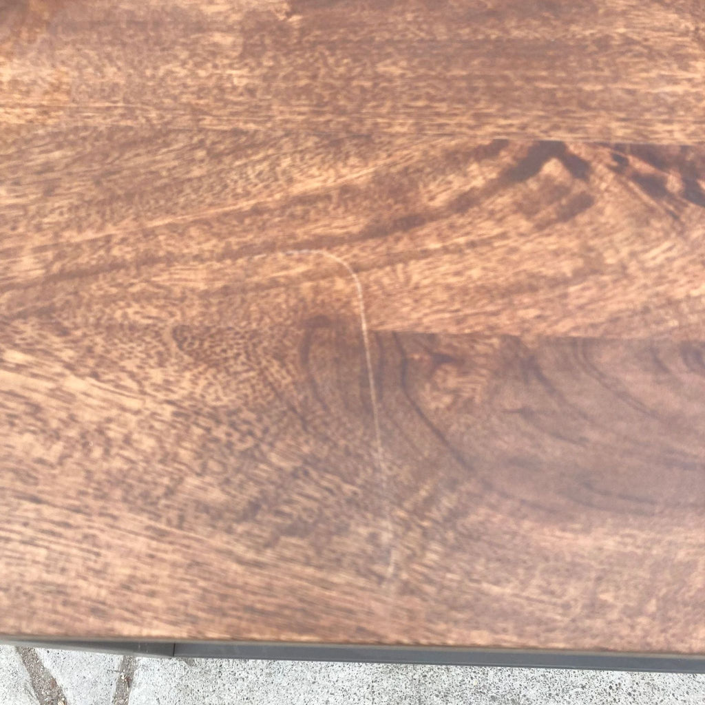 Close-up of the walnut-finished mango wood top of a West Elm coffee table.