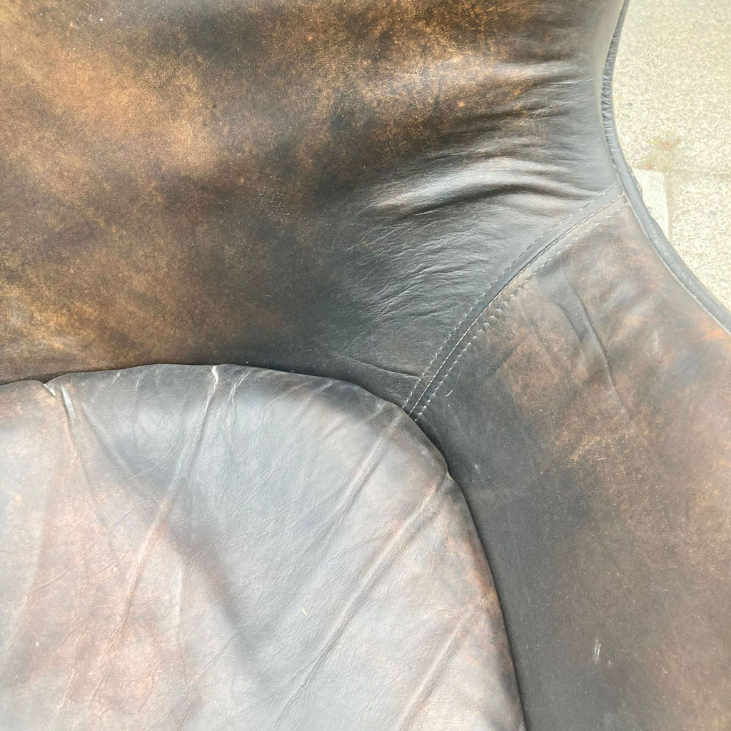 2. "Close-up of a Reperch lounge chair showcasing the rich, textured dark brown leather upholstery and detailed stitching."