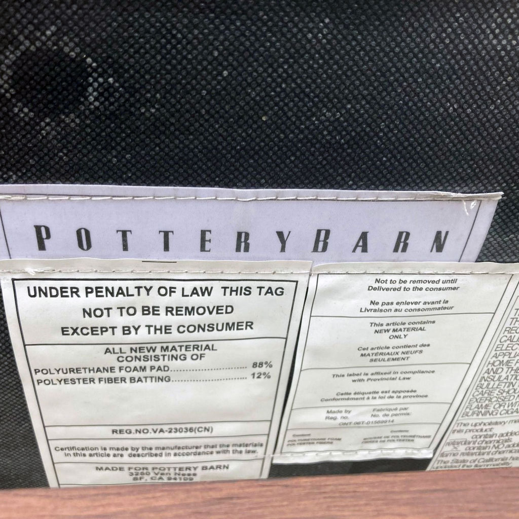 2. "Close-up of the Pottery Barn label on a black upholstered item with product material information."