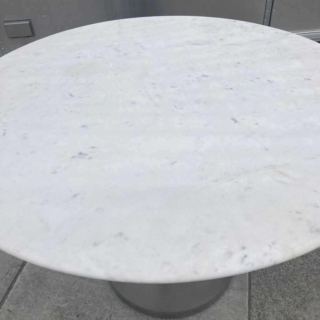 Reperch dining table showcasing marble top and metal base from a high angle.