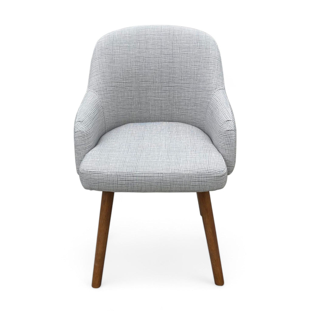 West Elm dining chair with a gray upholstered barrel back seat and solid wood legs.