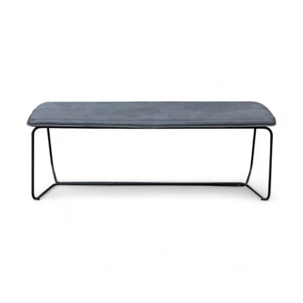 West Elm modern bench with a metal frame and upholstered leather cushion in a neutral setting.