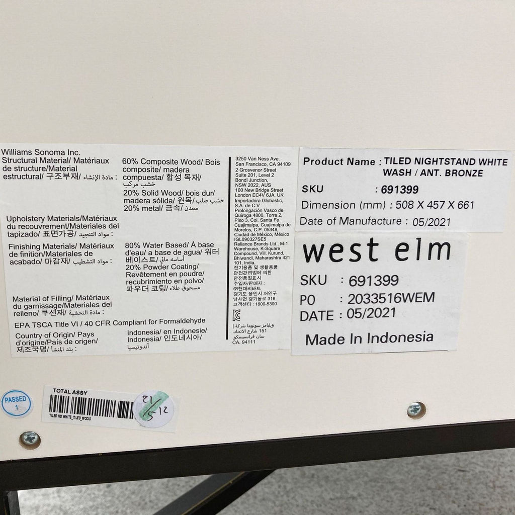 Close-up of the production label on a West Elm end table, detailing materials, SKU, and manufacture date.