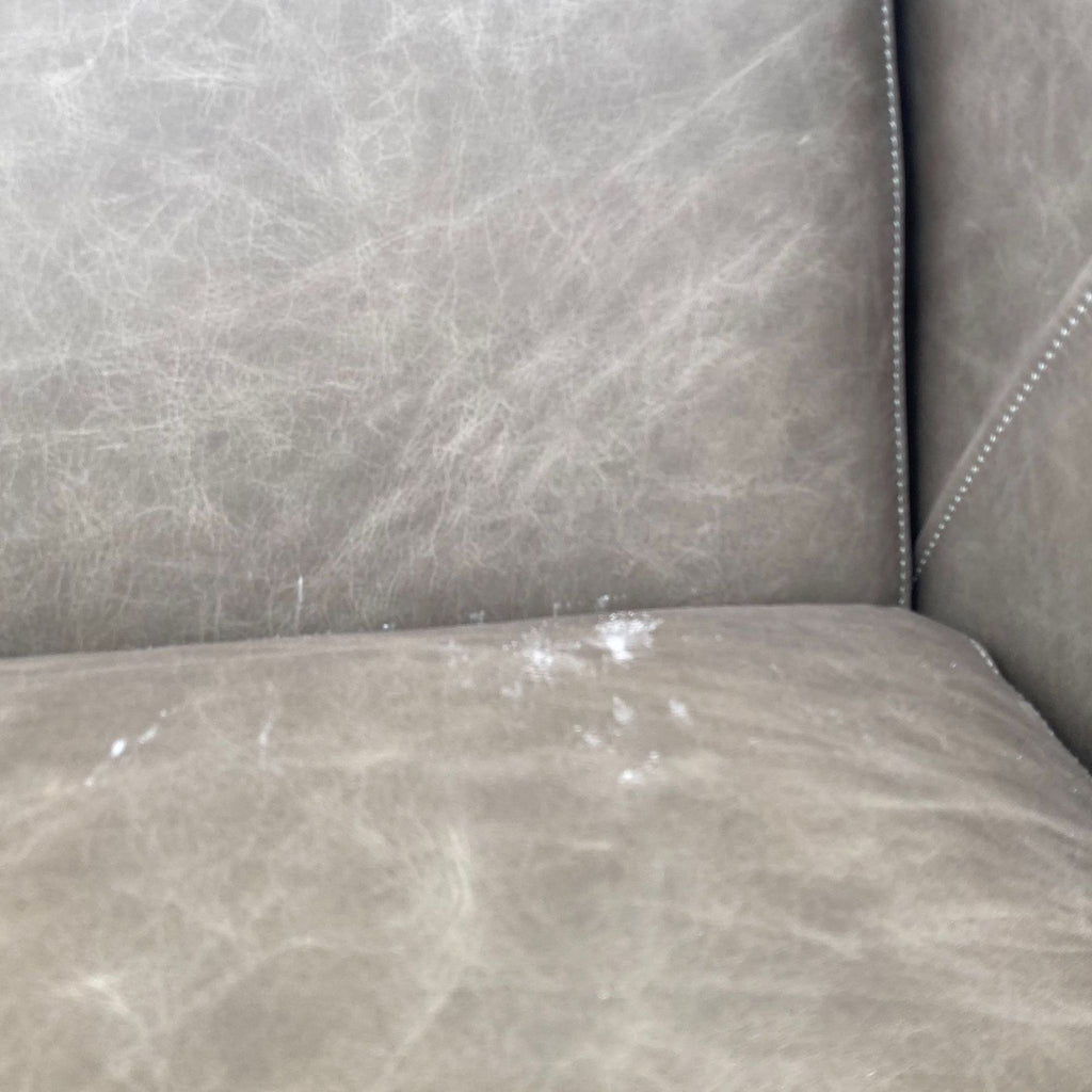 2. Close-up texture of the leather upholstery on the Austin lounge chair by West Elm, showing slight wear and markings.