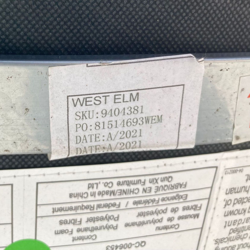 3. Detailed view of West Elm's product label on a grey leather upholstered Finley dining chair, confirming item specifics and brand.