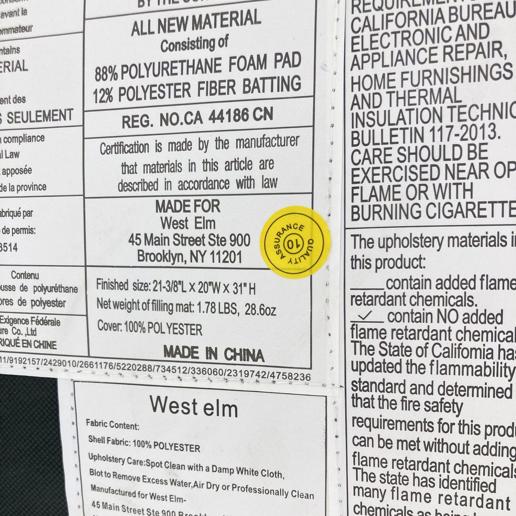 Label on West Elm Lenox dining chair reveals material composition, size, and warnings, including a 'no added flame retardant chemicals' certification.