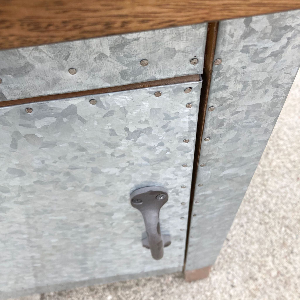 3. Detail of Pottery Barn sideboard corner showing galvanized metal door, handle, and wooden frame construction.