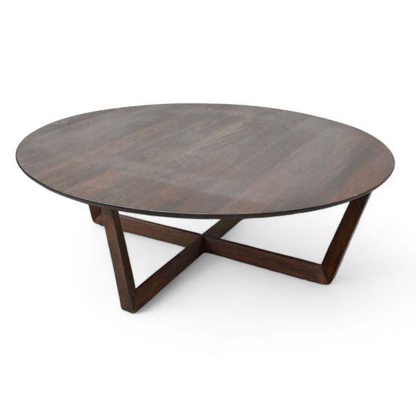 West Elm coffee table with a round top and intersecting wood base on a white background.