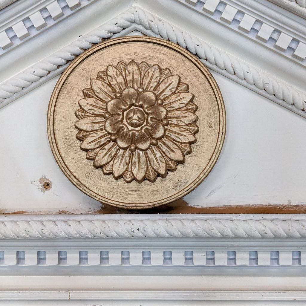 Close-up of a decorative wooden medallion with floral design, framed by rope molding on a Victorian backdrop.