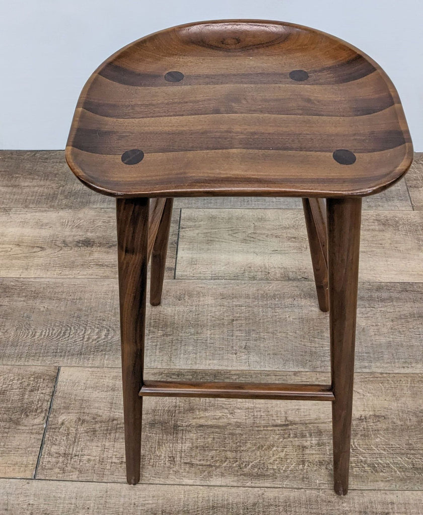 Tractor seat stool features walnut finish and contour design, ideal for counters.