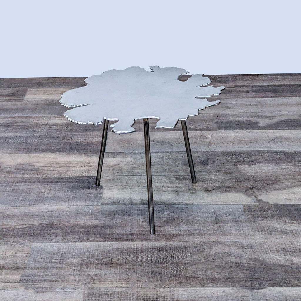 Reperch brand end table with amorphous tabletop on three metal legs against a wooden floor background.
