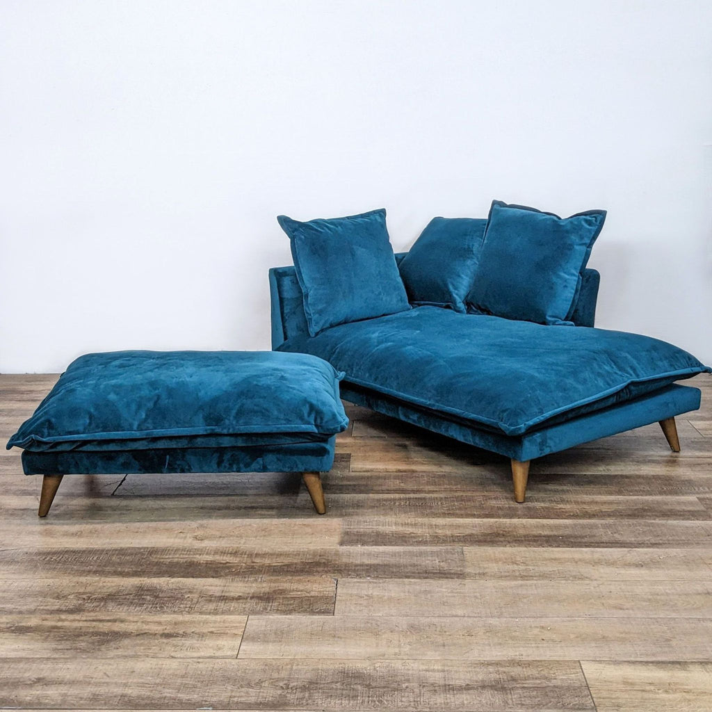 Velvet upholstered Denna chaise lounge and matching ottoman from Joybird Furniture, presented in rich peacock color with angled wooden supports.
