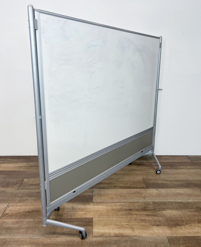 Alt text 2: Mobile double-sided whiteboard with a metal frame and sturdy base positioned on a wood floor.