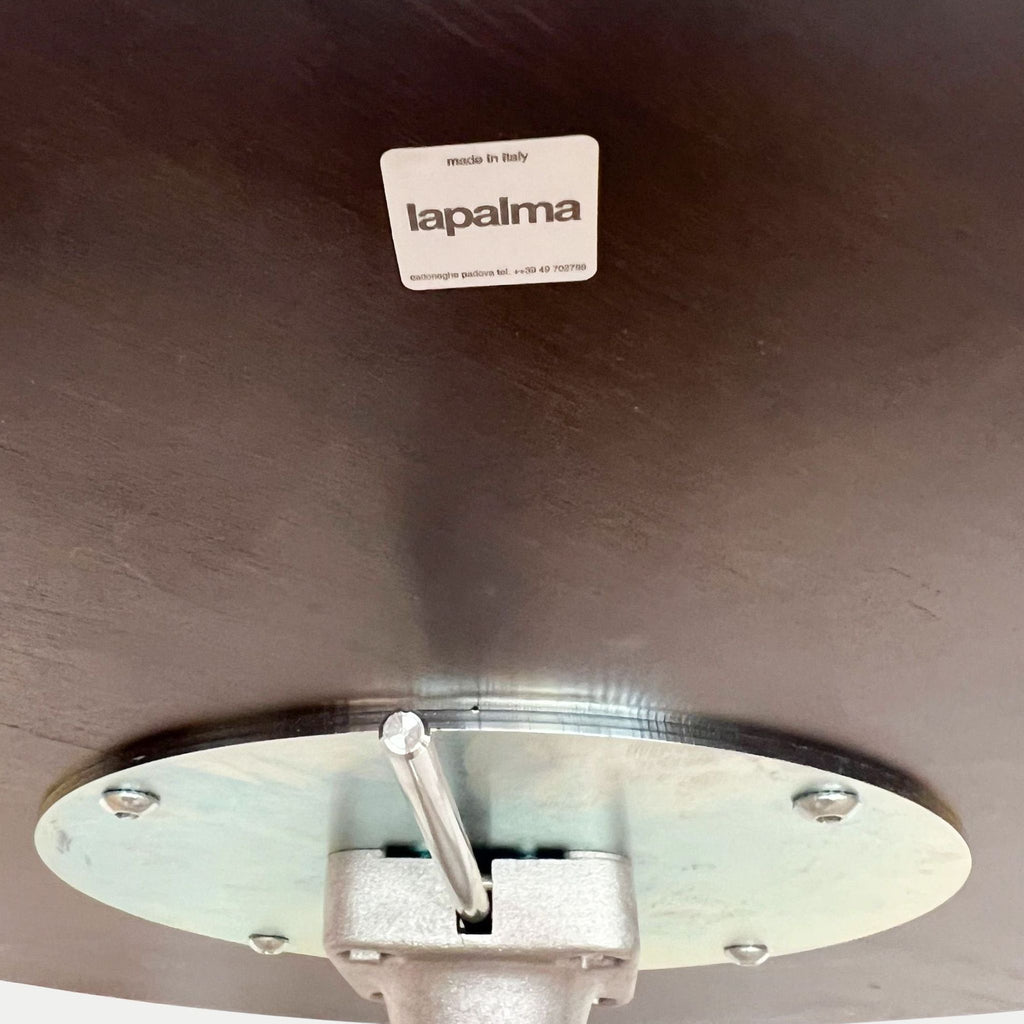 Close-up of Brio table underside showing a wood top, height-adjustment mechanism, and Lapalma branding.