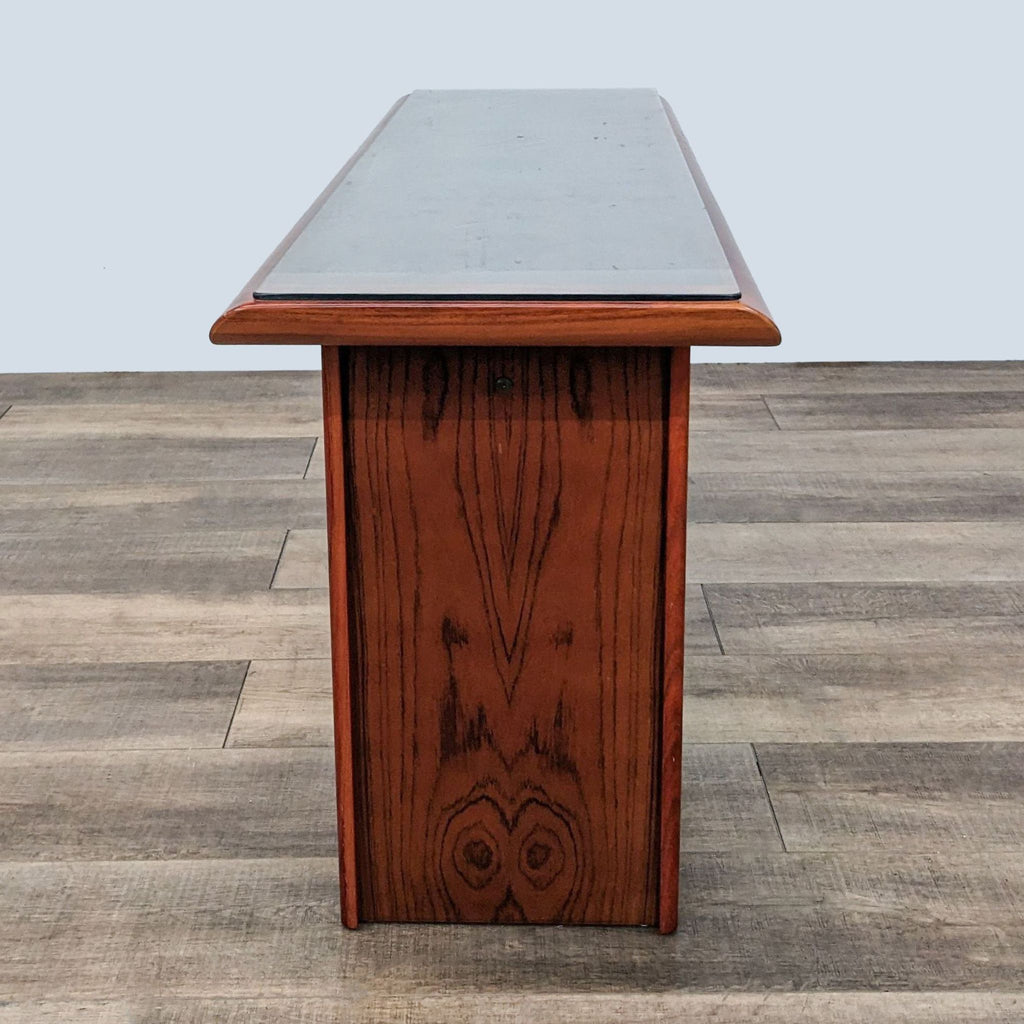 2. "Side view of a Reperch wooden side table showing wood grain detail, on a herringbone pattern floor."