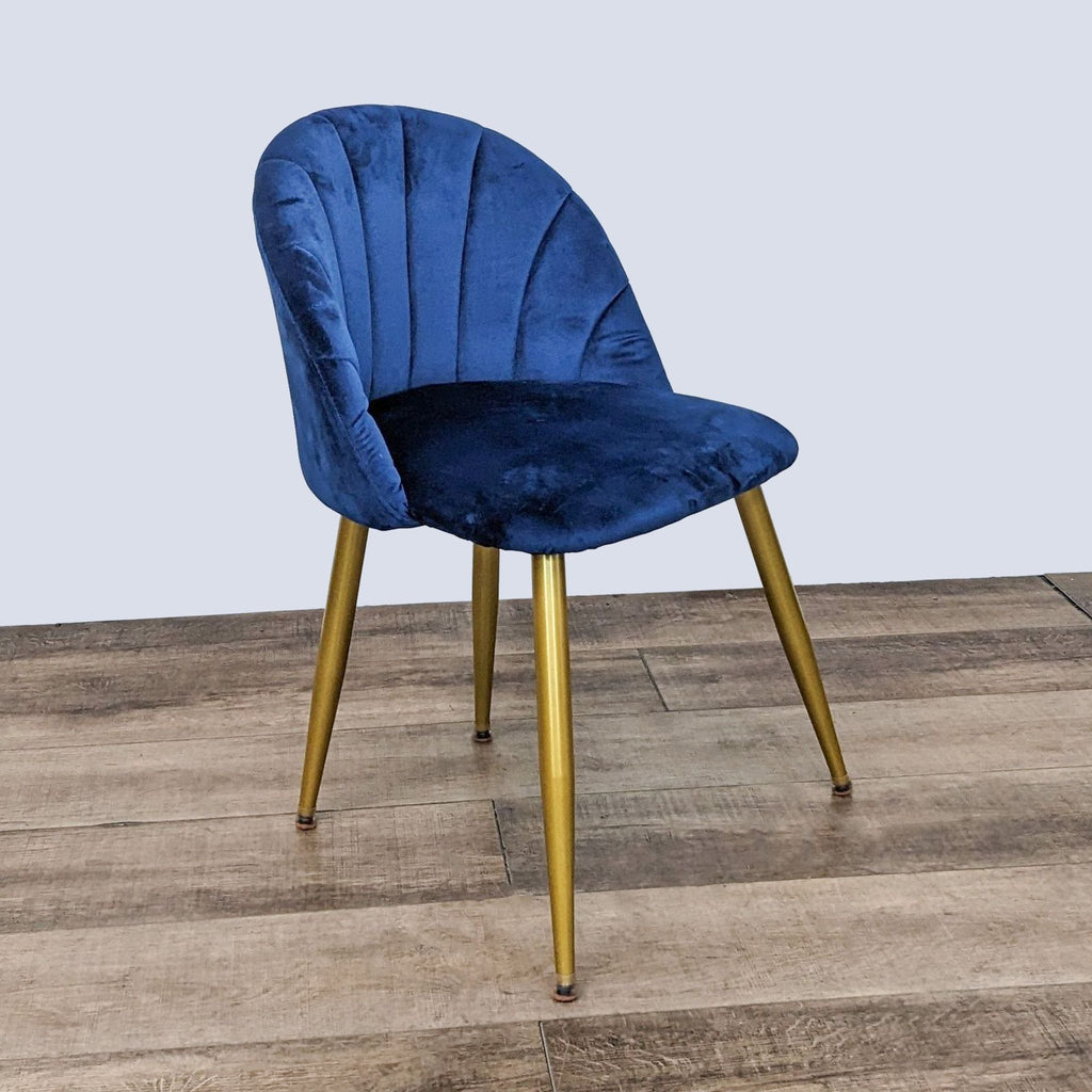 Blue velvet tufted Reperch accent dining chair with a metal frame and golden legs, angled view on a wood floor.