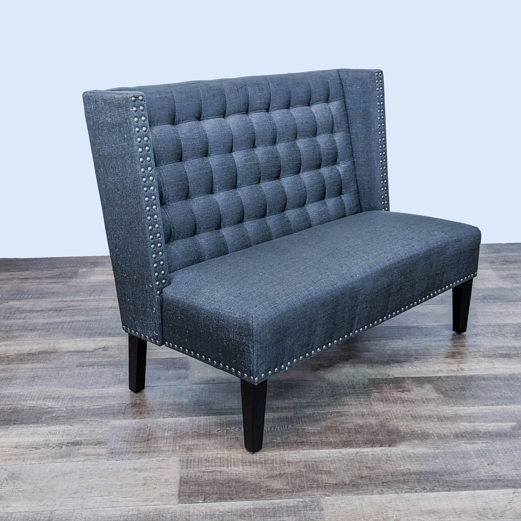 Side view of dark grey high-back loveseat, featuring nailhead detailing.